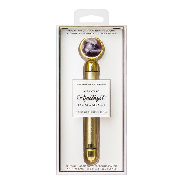 Gold facial massager with amethyst stone in packaging on a white background