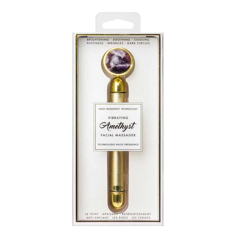 Gold facial massager with amethyst stone in packaging on a white background