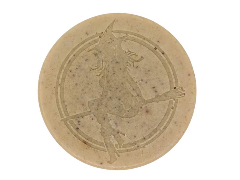 round beige soap stamped with witch and speckled with herbs